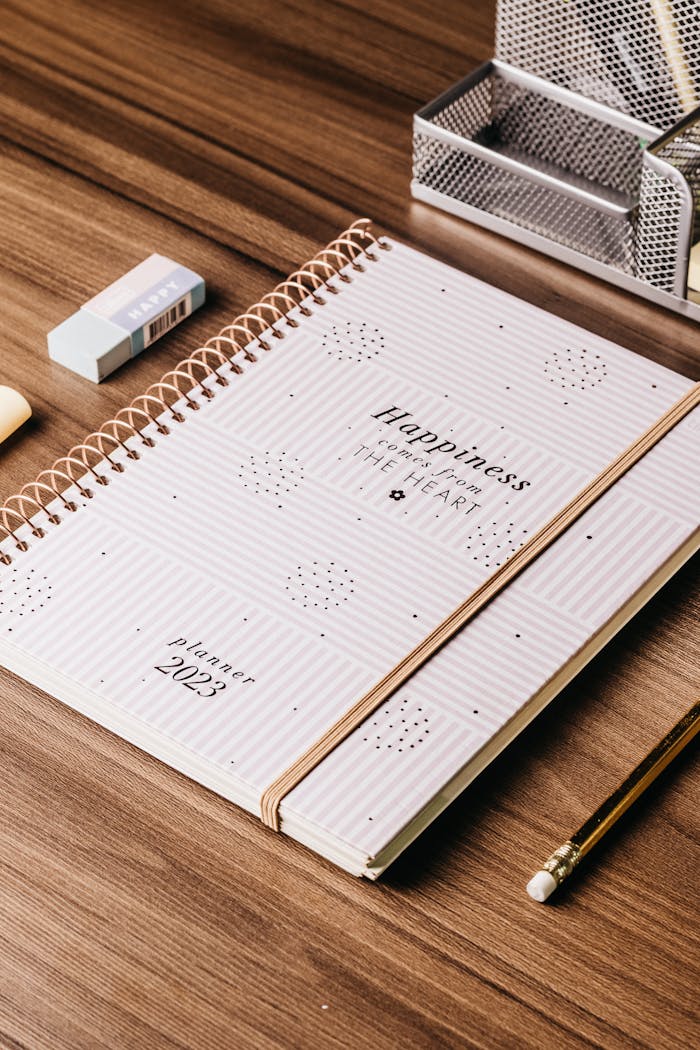 services-03 A 2023 planner with stationery items on a wooden desk, perfect for organizing.