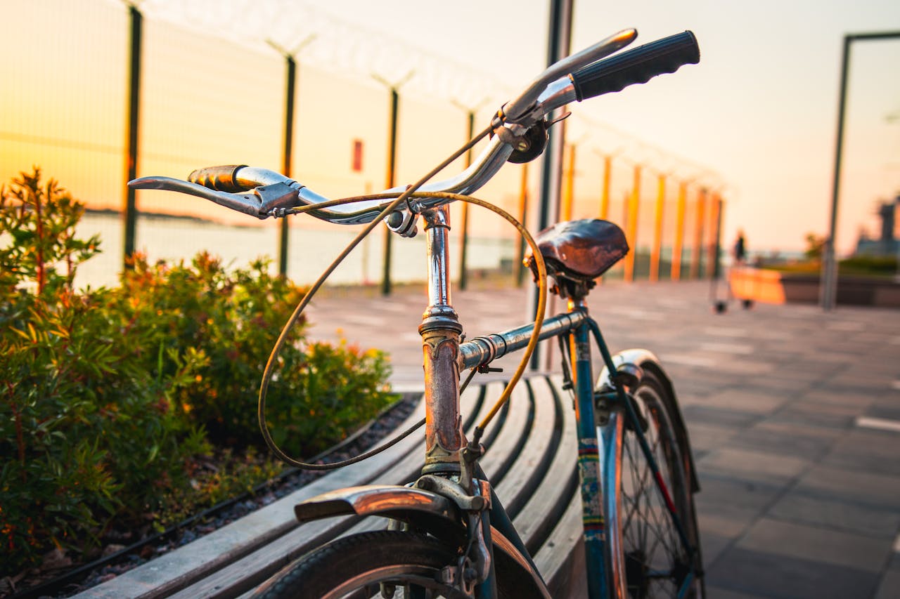 A vintage bicycle parked by a scenic path in Tallinn during a stunning sunset.
