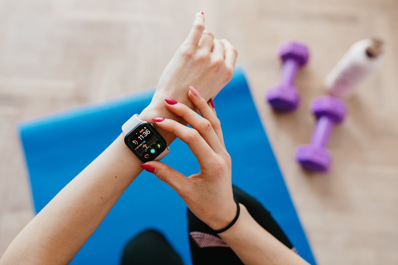 story-02 A woman checks fitness data on her smartwatch during a workout at home.