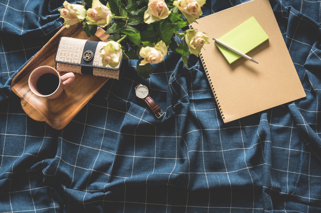 services-01 A cozy flatlay showing coffee, roses, notebook, and watch on a checkered blanket.